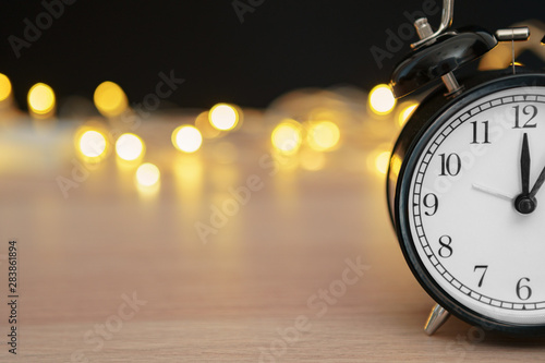 Close up of retro alarm clock on blurred Christmas background with bokeh