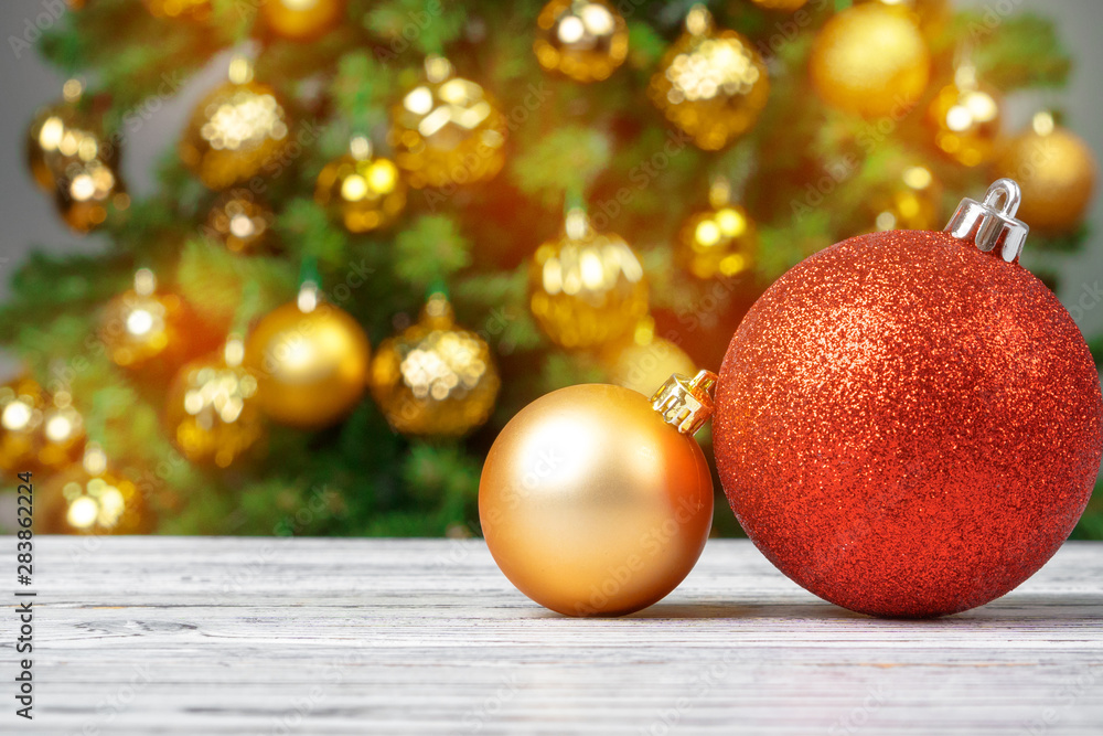 Christmas baubles on wooden table against decorated christmas tree blurred background Christmas baubles on wooden table against decorated christmas tree blurred background