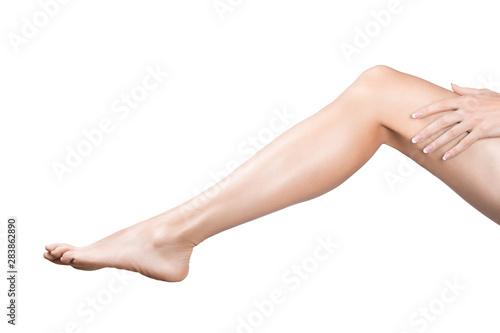 Female sexy leg with smooth skin. Woman puts her hand on hip, isolated on white.