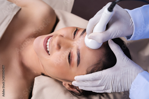 woman receiving ultrasound facial beauty treatment skin care