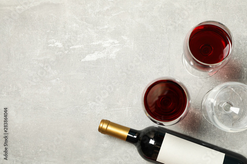 Εκτύπωση καμβά Flat lay composition with bottle and glasses of wine on grey background, copy sp