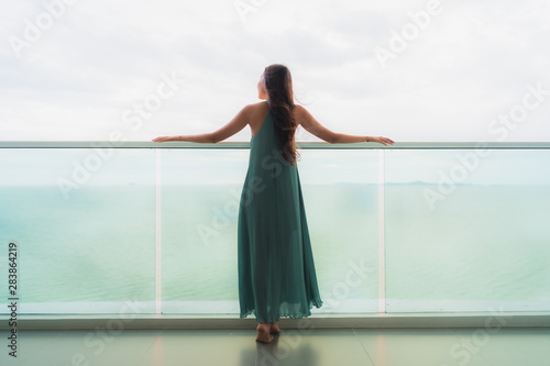 Canvas Print Beautiful portrait young asian woman happy smile relax at balcony with sea ocean