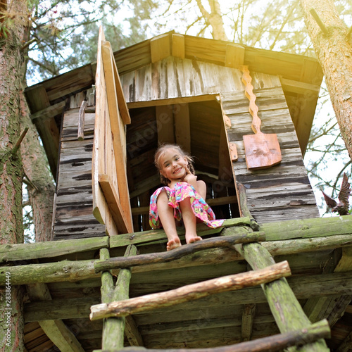 Happy cute kid playing in the treehouse photo