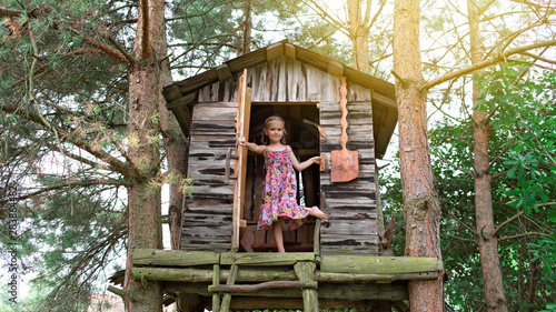 Happy cute kid playing in the treehouse