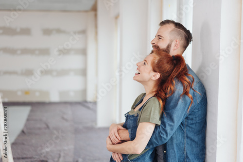 Canvas Print Laughing happy affectionate couple in a new home
