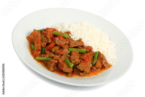 meat with rice and vegetables on plate isolated on white