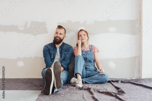 Young couple sitting on the floor side by side