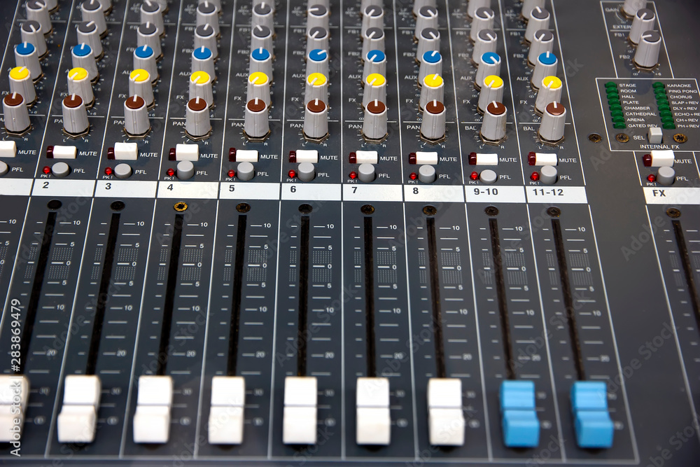 Audio sound mixer console. Music mixer control panel in a recording studio. Audio mixing console with faders and adjusting knob.