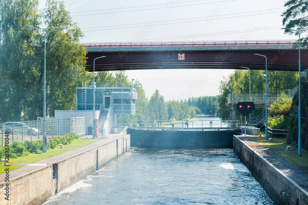 Lappeenranta, Finland - August 7, 2019: Lock and bridge on the Saimaa Canal at Malkia. Engineers are finding out the reason for the failure of the gateway. View from water.
