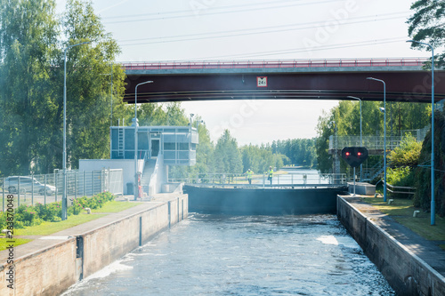 Lappeenranta, Finland - August 7, 2019: Lock and bridge on the Saimaa Canal at Malkia. Engineers are finding out the reason for the failure of the gateway. View from water. © Elena Noeva