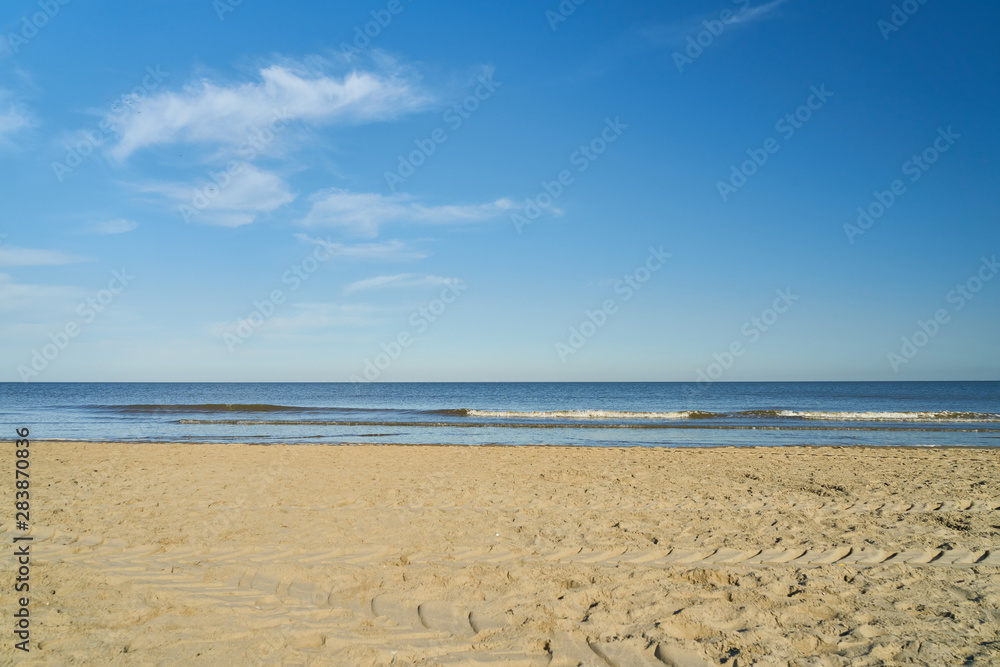 Leerer Strand an Nordsee vor blauem Himmel