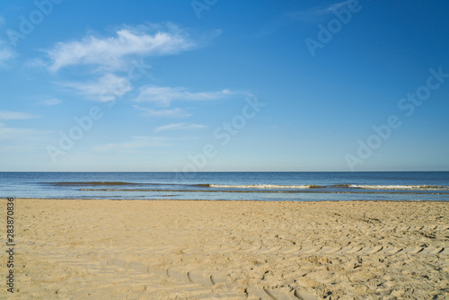 Leerer Strand an Nordsee vor blauem Himmel