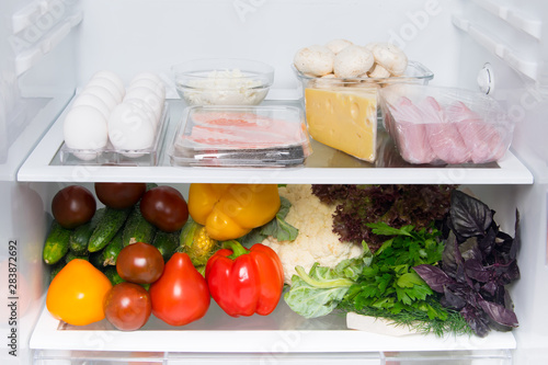 in a white refrigerator, food stock, on the top shelf eggs, fish, mushrooms, cottage cheese, meat, cheese, and vegetables on the bottom