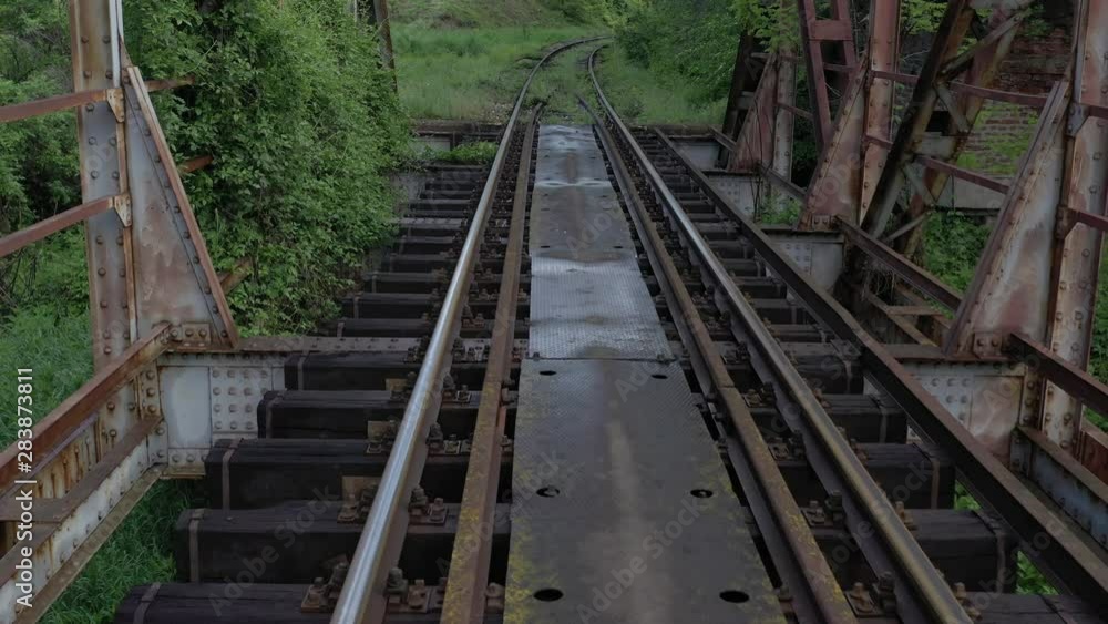 Backwards flying over the old style bridge with railway track 4K drone footage Backwards flying over the old style bridge with railway track 4K drone footage