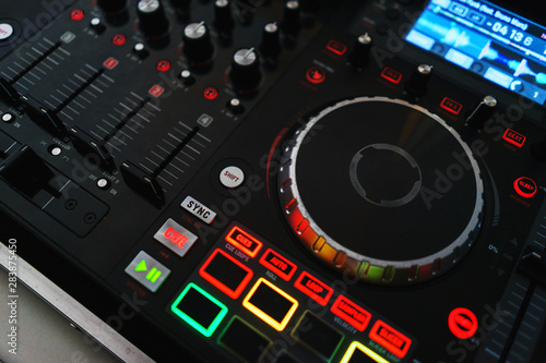 Bright buttons and switches on the DJ console during the performance.