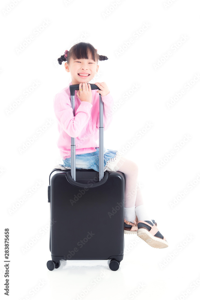 Little asian girl sitting on wheel suitcase and smiles over white background Little asian girl sitting on wheel suitcase and smiles over white background