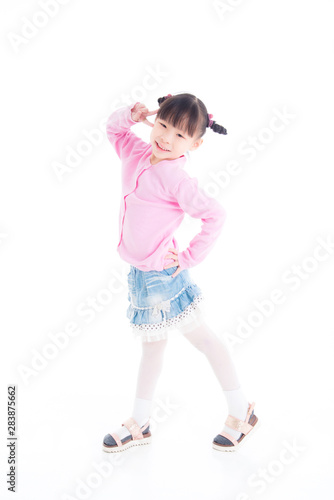 Little asian girl standing and smiles over white background