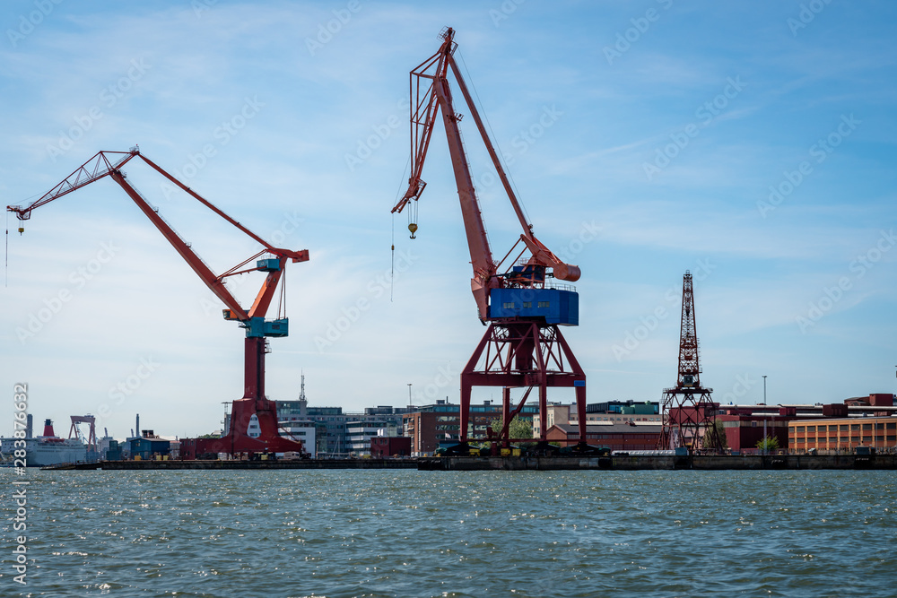 Summer seascape view of two large harbor cranes against blue sky in Gothenburg Sweden.