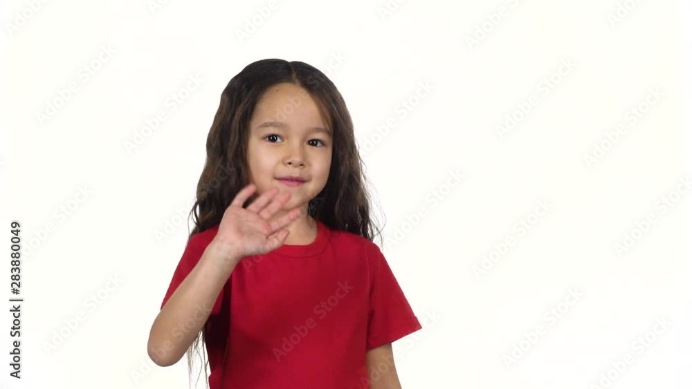 Little dark-haired kid waving with hand on white background. Slow motion Little dark-haired kid waving with hand on white background. Slow motion
