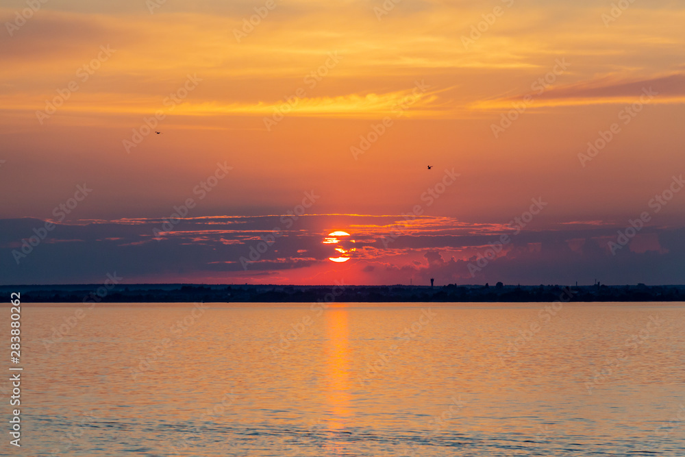 Sunset on the Volga river in Russia in July. Orange sun in the sky. Picturesque nature. Summer evening. River cruise Sunset on the Volga river in Russia in July. Orange sun in the sky. Picturesque nature. Summer evening. River cruise