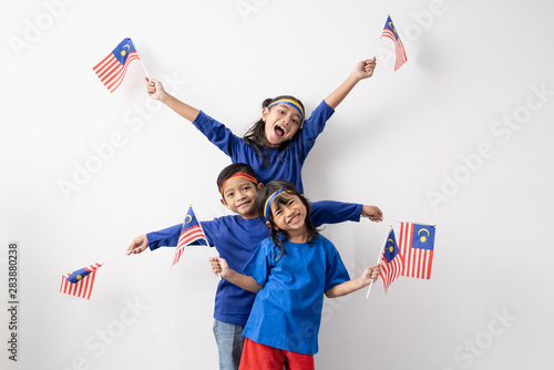 happy excited malaysian kids with malaysia flag over white background photo