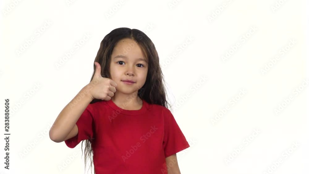 Portrait smart kid showing thumbs up her hands on white background. Slow motion Portrait smart kid showing thumbs up her hands on white background. Slow motion