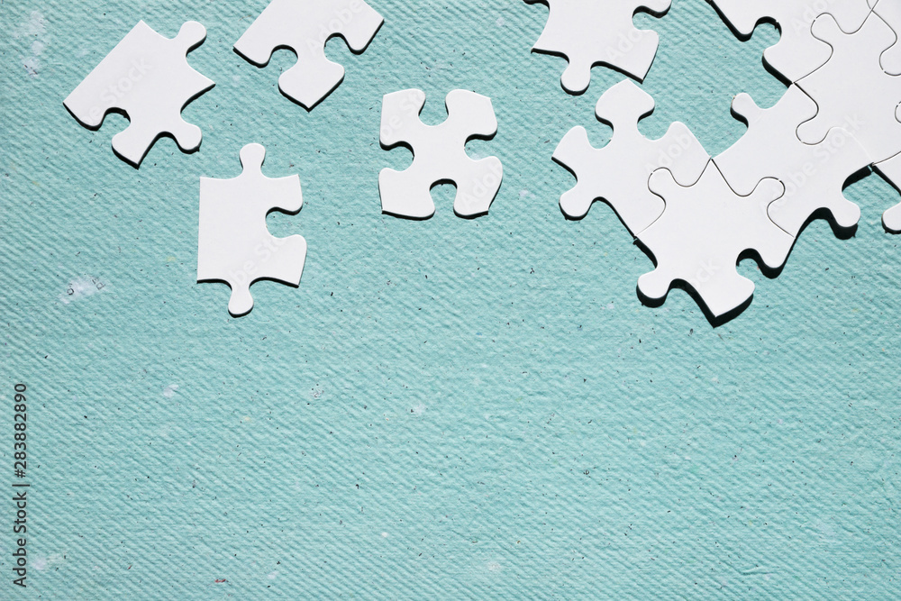 Obraz premium White jigsaw puzzle piece over blue textured surface
