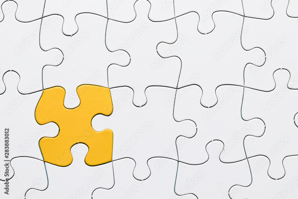 Yellow puzzle among white jigsaw puzzle grid Yellow puzzle among white jigsaw puzzle grid