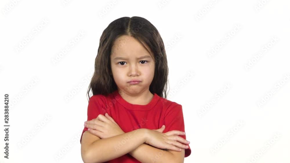 Portrait of little girl crosses hands posing at white background. Slow motion Portrait of little girl crosses hands posing at white background. Slow motion