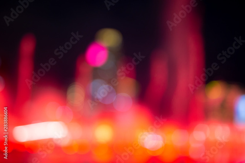 Fountain show with red bokeh color light illumination abstract.