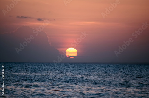 Fototapeta Naklejka Na Ścianę i Meble -  Sunset over calm sea water in pink evening clouds