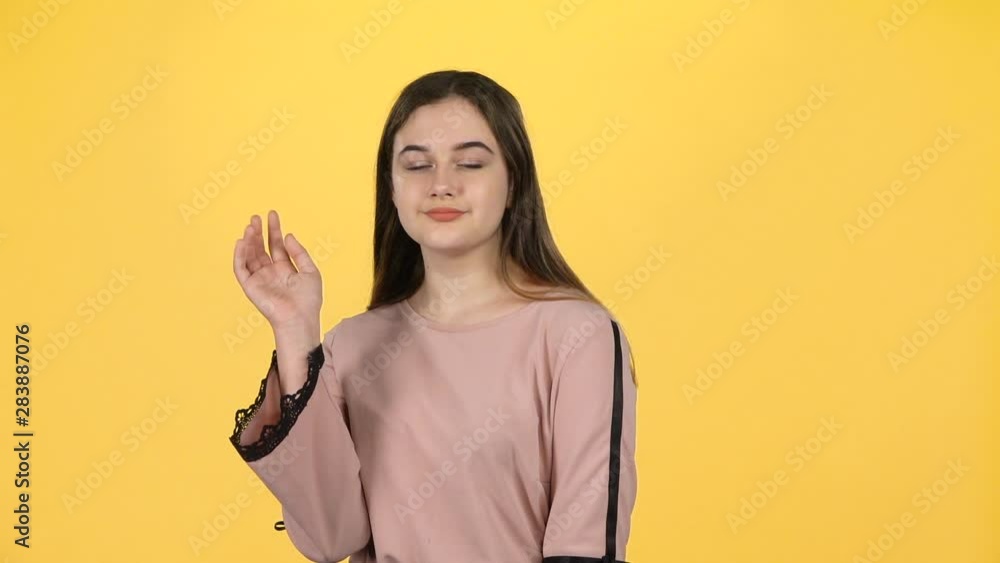 Youngful girl waving with hands on yellow background. Slow motion Youngful girl waving with hands on yellow background. Slow motion