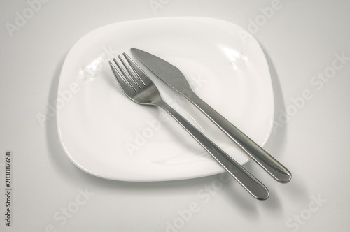 empty plate with fork and knife on white background