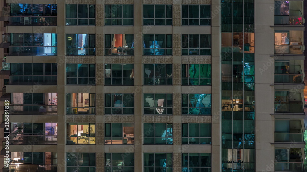 Windows of the multi-storey building with lighting inside and moving people in apartments timelapse. Windows of the multi-storey building with lighting inside and moving people in apartments timelapse.