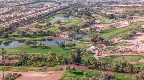 Aerial view to villas and houses with Golf course with green lawn and lakes timelapse