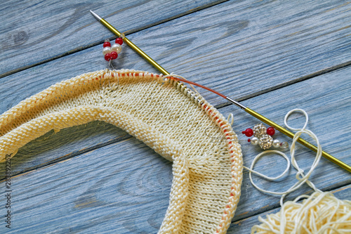 Bild auf Leinwand Yellow knitted handmade raglan or jumper on blue wooden background