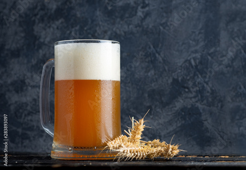 Glass mug of wheat unfiltered beer on the background of a concrete wall in the pub with copy space photo