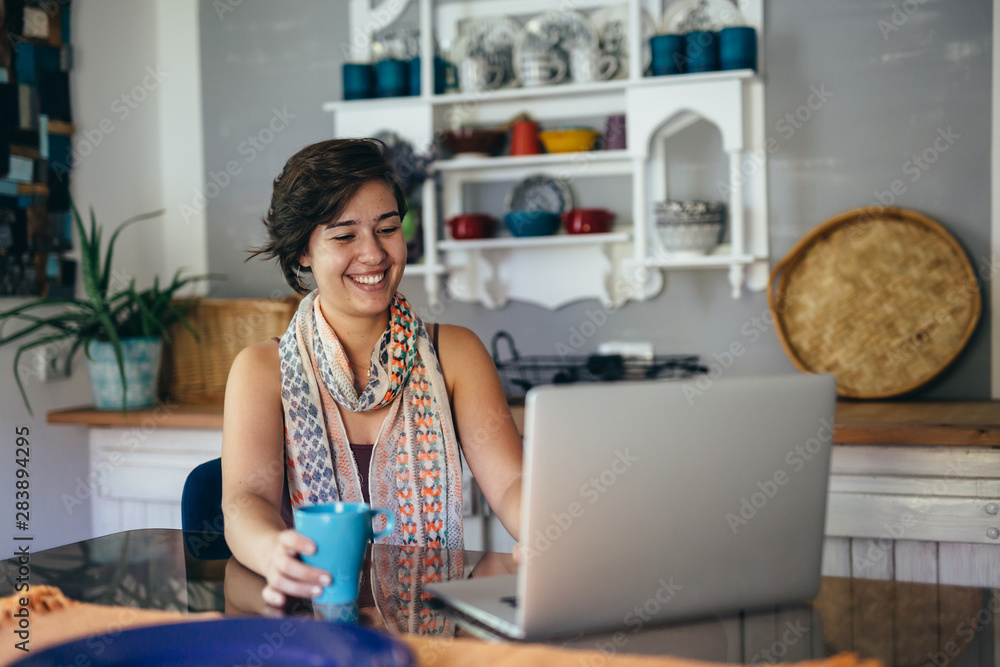she is always on line with her friends. woman using laptop at her home she is always on line with her friends. woman using laptop at her home