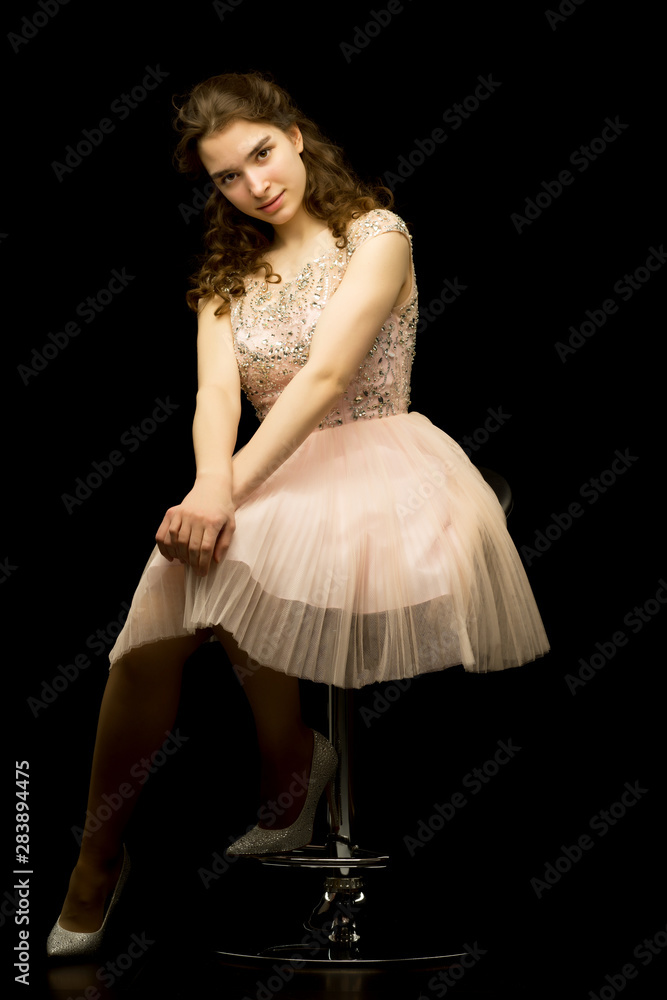 Naklejka premium Fashionable girl teenager studio photo on a black background.