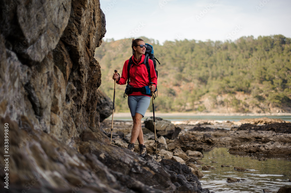 Woman in sportwear walking on the rock with hiking backpack Woman in sportwear walking on the rock with hiking backpack