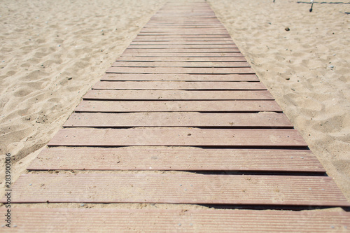 Wooden walking path along sandy shore. beach path photo