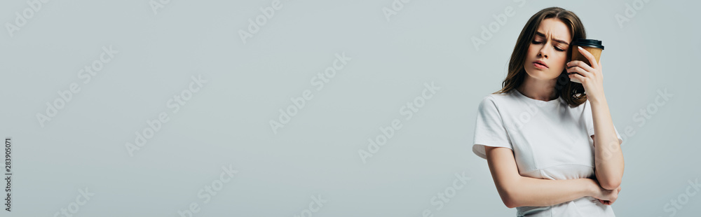 beautiful girl in white t-shirt with migraine holding paper cup isolated on grey, panoramic shot beautiful girl in white t-shirt with migraine holding paper cup isolated on grey, panoramic shot