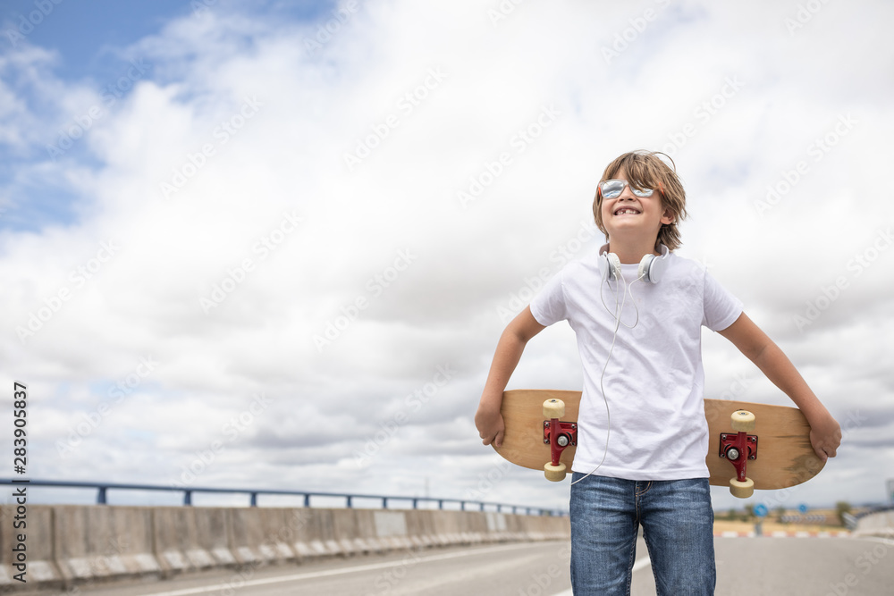 cheerful and smiling boy with glasses and skateboard cheerful and smiling boy with glasses and skateboard