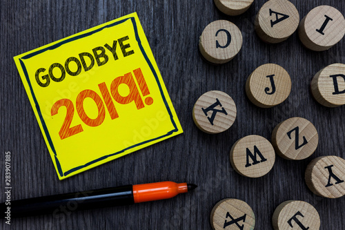 Conceptual hand writing showing Goodbye 2019. Business photo showcasing New Year Eve Milestone Last Month Celebration Transition Yellow paper circle Marker express ideas wooden background photo