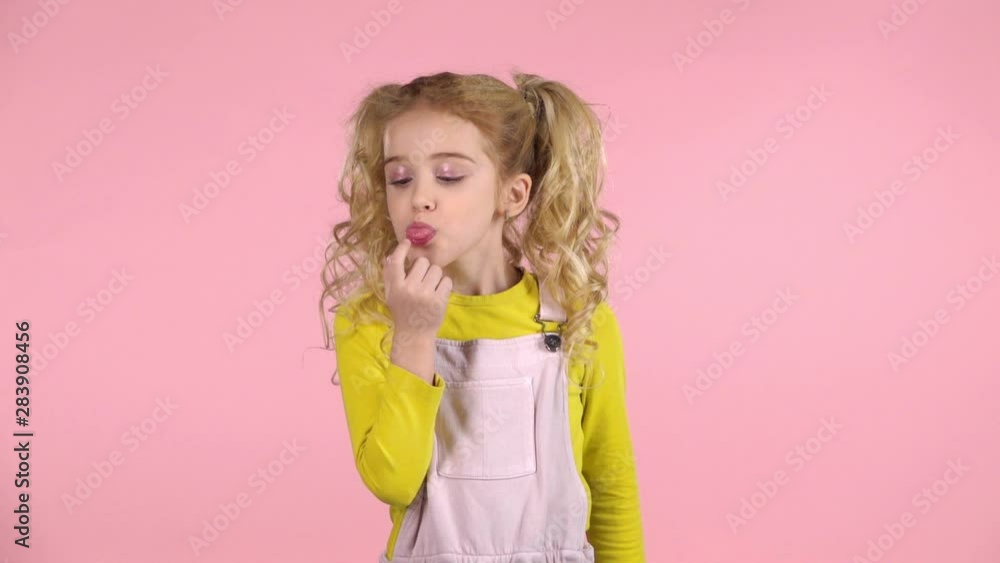 Cute naughty girl making faces on pink background. Slow motion Cute naughty girl making faces on pink background. Slow motion