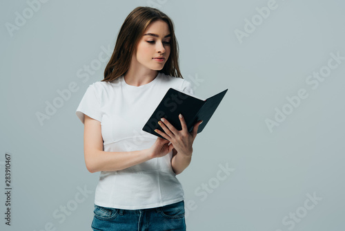 beautiful girl in white t-shirt reading book isolated on grey