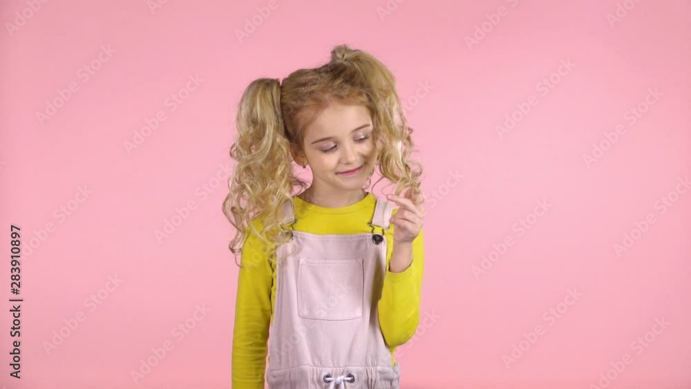 Cute female child is winding her hair on the finger. Slow motion Cute female child is winding her hair on the finger. Slow motion