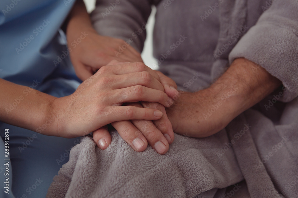 Female doctor consoling active senior man in a comfortable home Female doctor consoling active senior man in a comfortable home