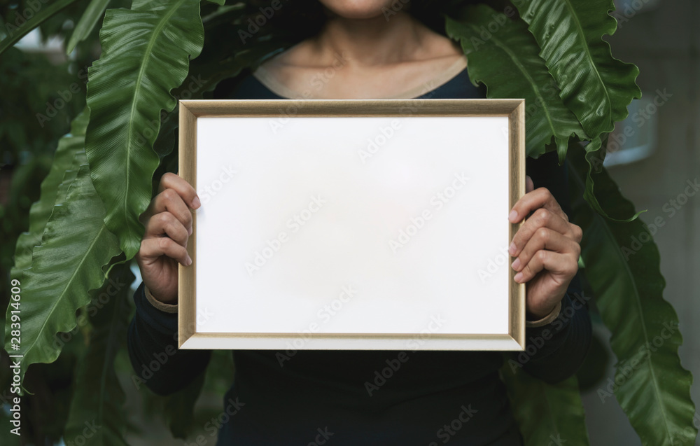 Hand Holding Blank Photo Frame for Design Mockup Template in the garden. Hand Holding Blank Photo Frame for Design Mockup Template in the garden.
