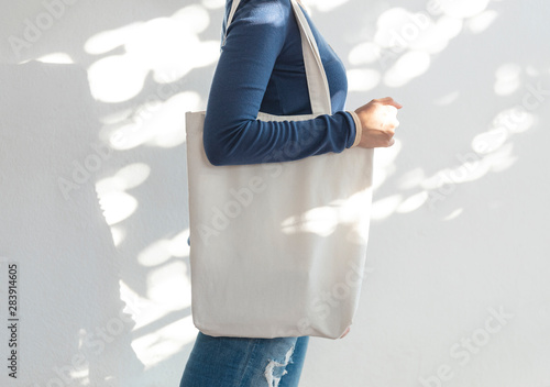 Girl is holding bag canvas fabric for mockup blank template on sunlight background.  global warming concept. photo